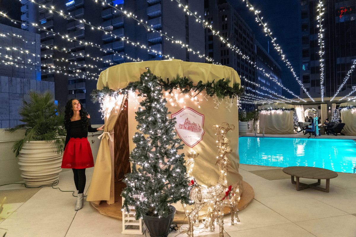 A woman beside a cozy holiday tent with a pool in the backgroud
