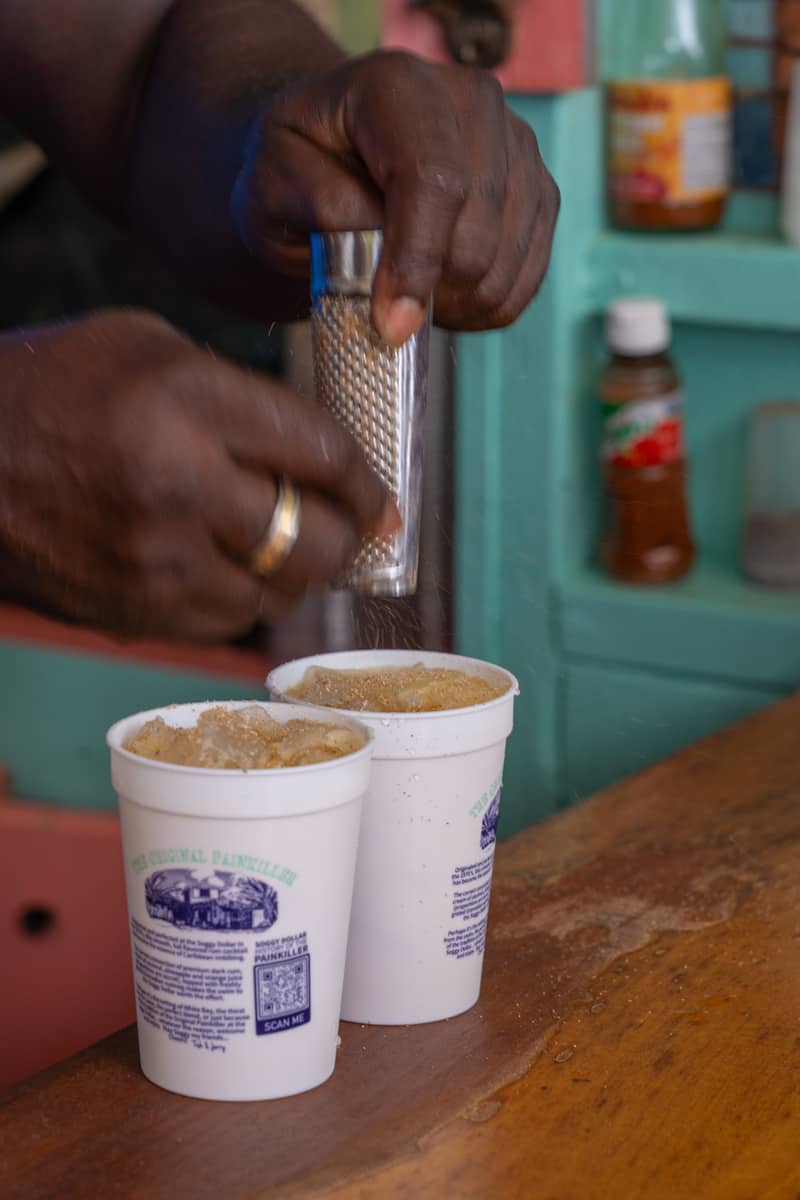 a person pouring ice into two cups