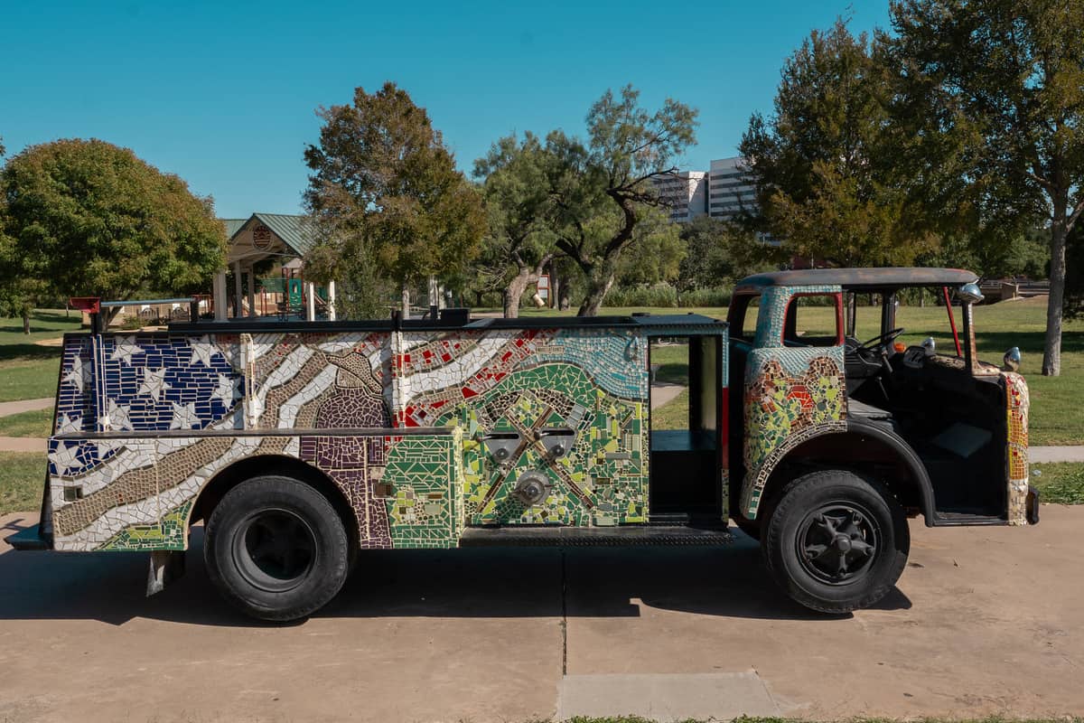 An antique firetruck covered in a mosaic depicting an American flag.