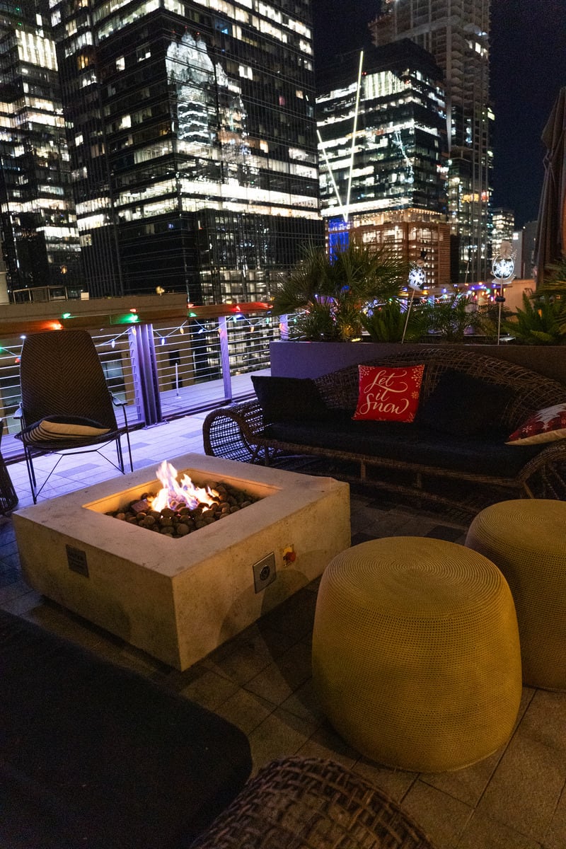A rooftop fire pit with a city skyline backdrop. The perfect spot to unwind and enjoy the city lights.