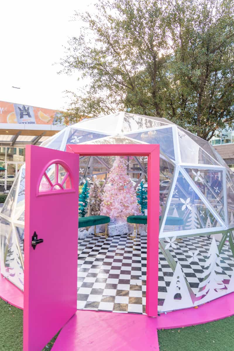 A cute i pink igloo with bench and christmas decors inside perfect for taking pictures.