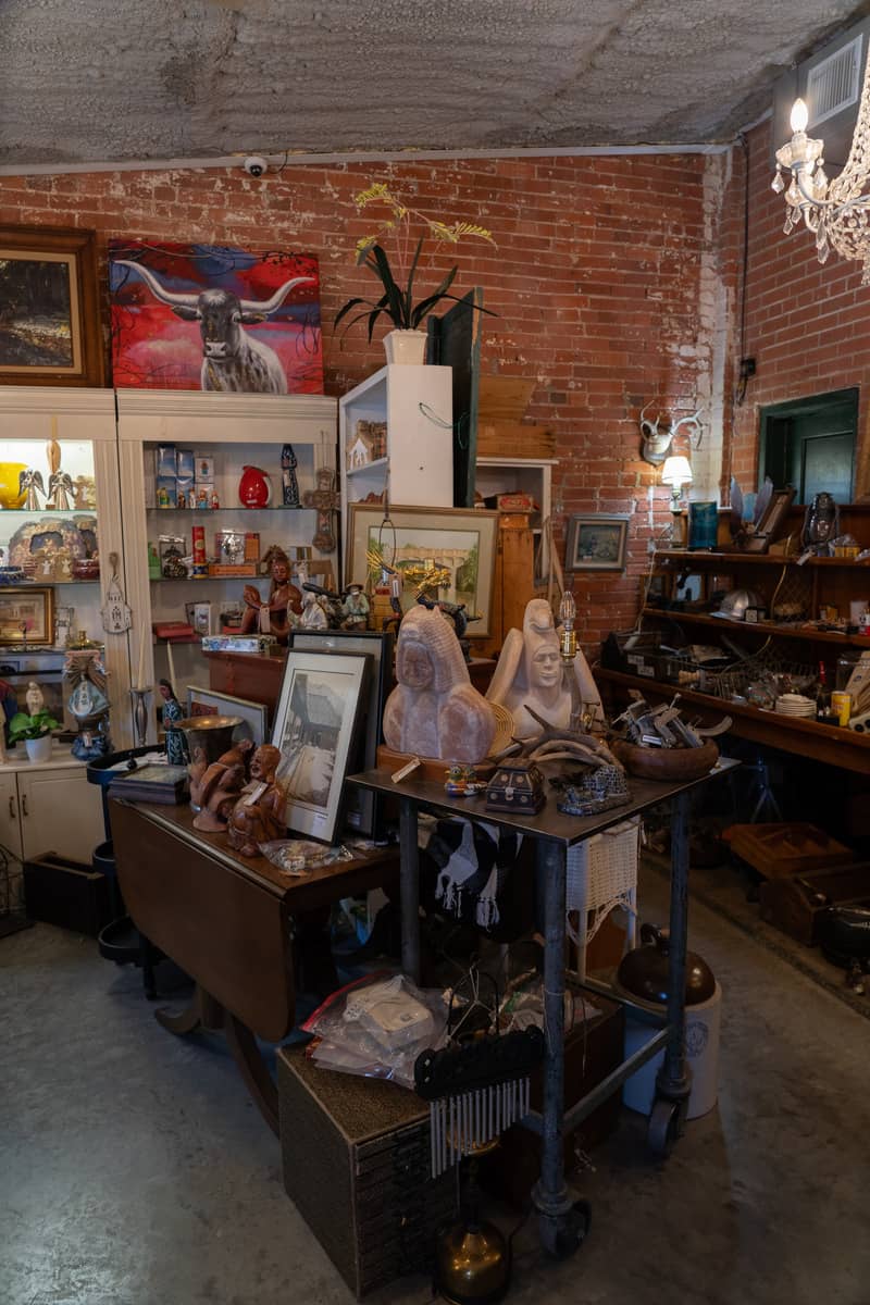 Display of antique items like dishware, statues, and other decor