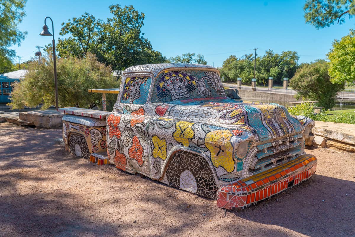 Mosaic-covered pick-up truck in a park