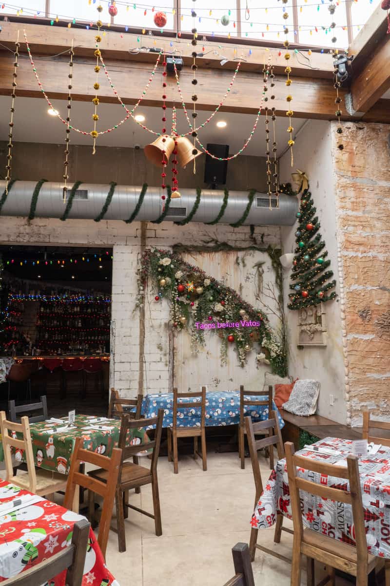 A bar with christmas decorations and tables and chairs with holiday table mats