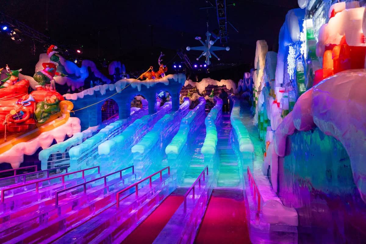 Colorful indoor ice slide attraction with neon lights and festive decorations.