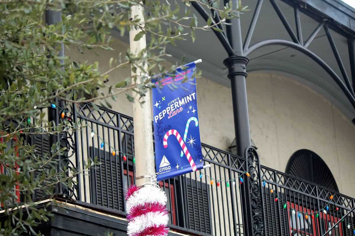 Banner reading "Peppermint Lane" with festive decor on a balcony