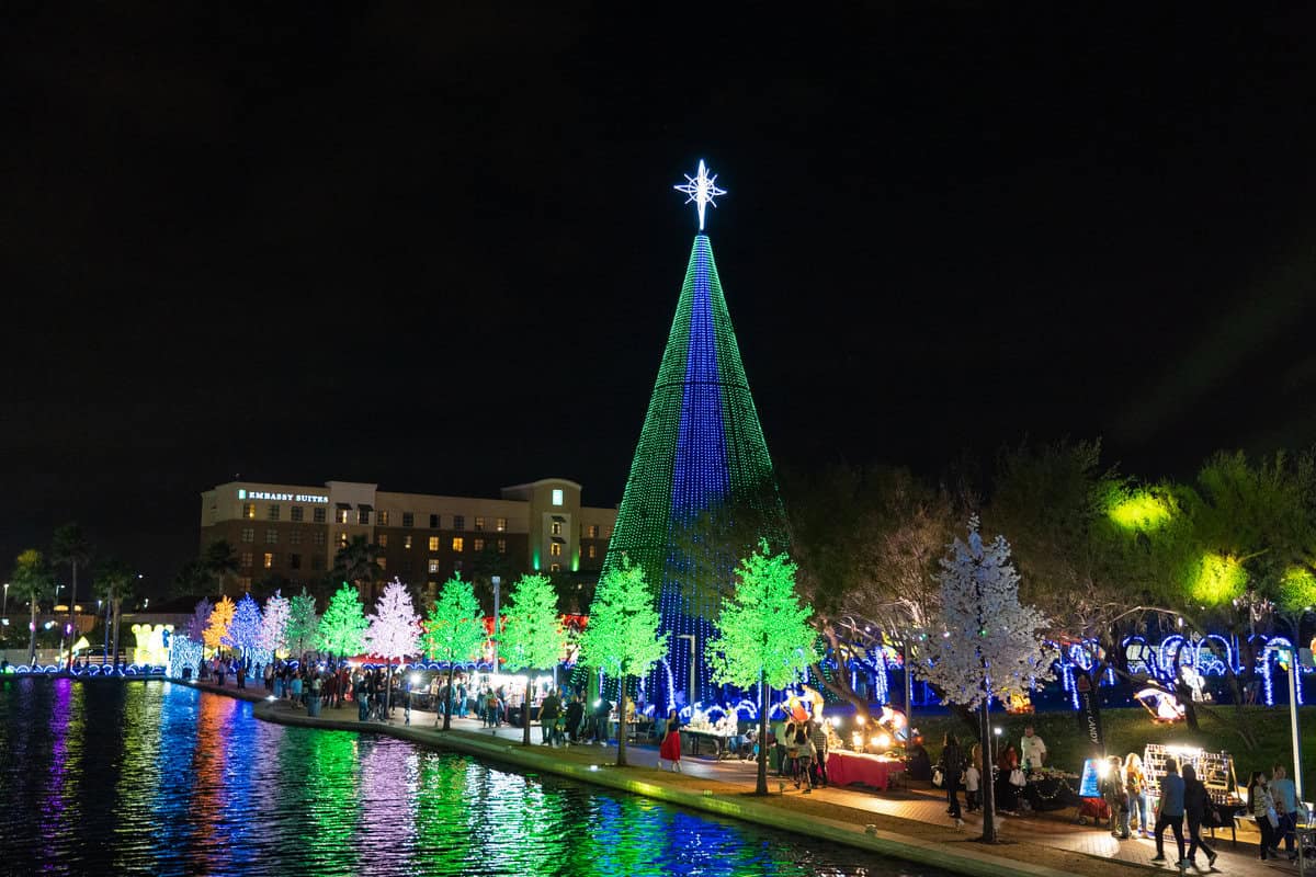 Illuminated holiday lights display by a riverside