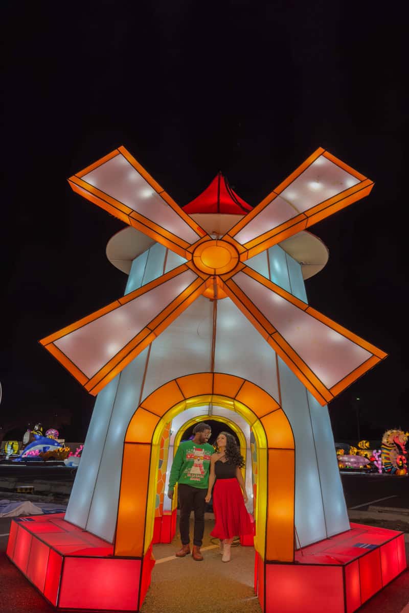 A couples having a pose inside a windmill design christmas display