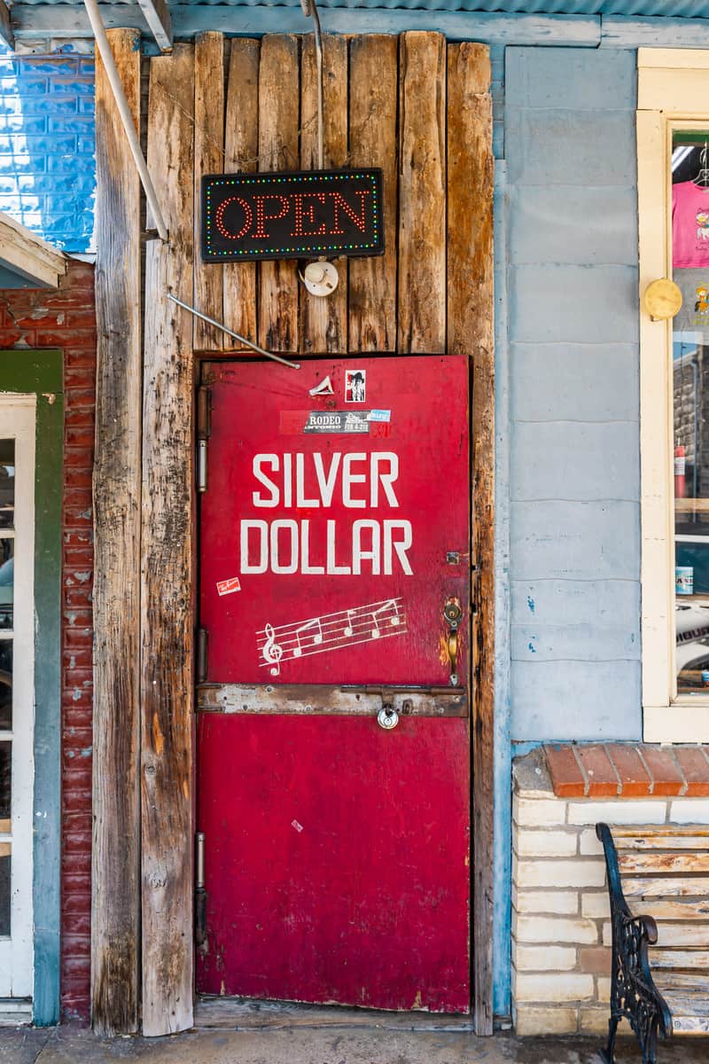 A worn, red door that says "Silver Dollar" on it