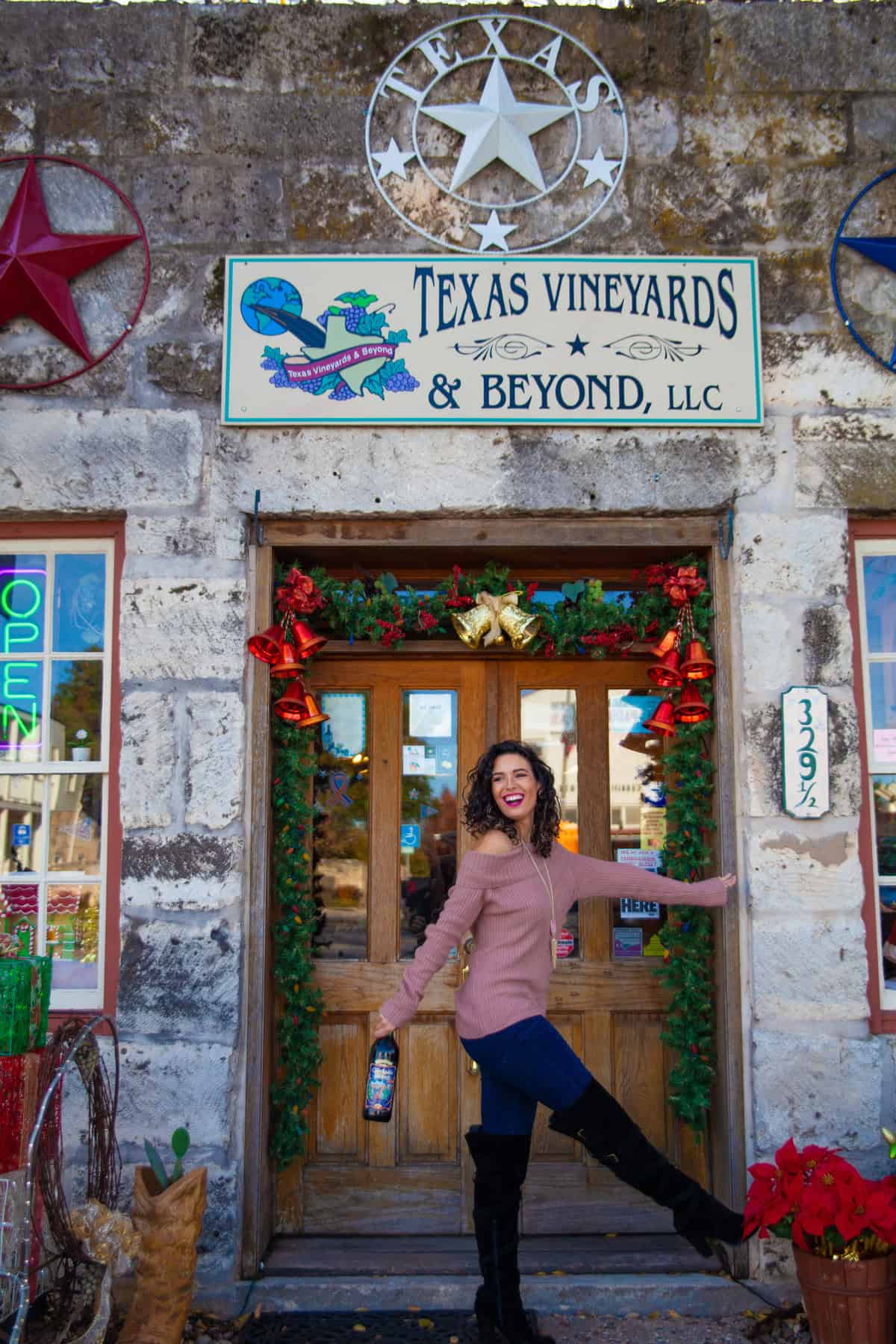 Person in front of a vineyard shop decorated with Christmas wreaths.