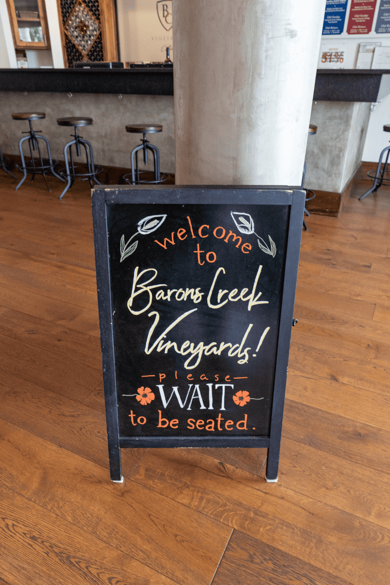 Welcome to Baron Creek Vineyard - a sign inside a tasting room