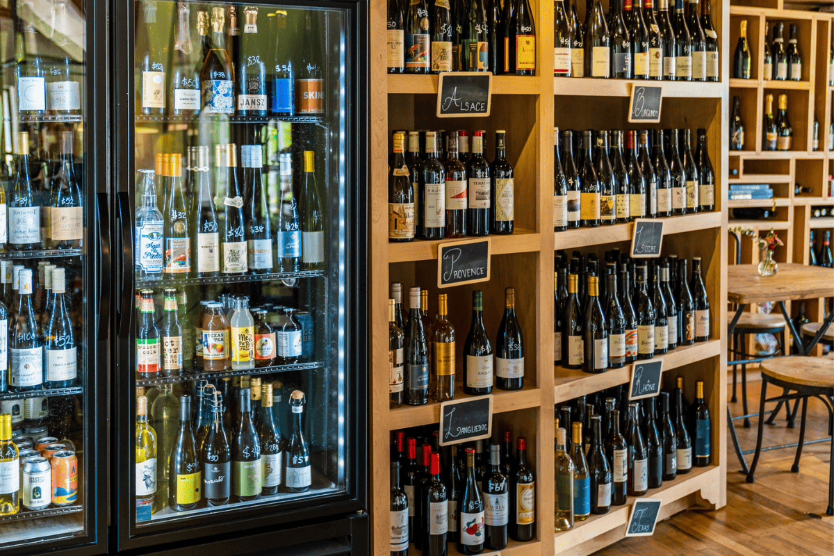 A wine store with a fridge full of wine. 