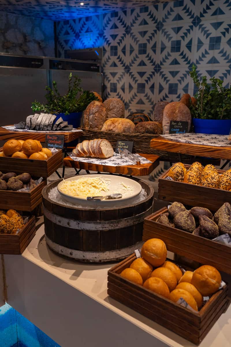 A variety of breads displayed on a table, showcasing different shapes, sizes, and textures.