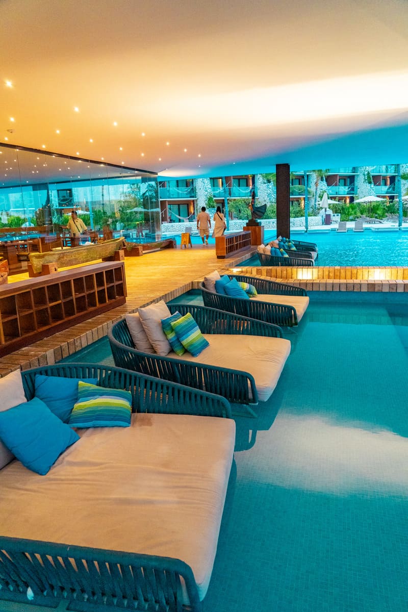A hotel pool area with lounge chairs and a bar, perfect for relaxing and enjoying a refreshing drink