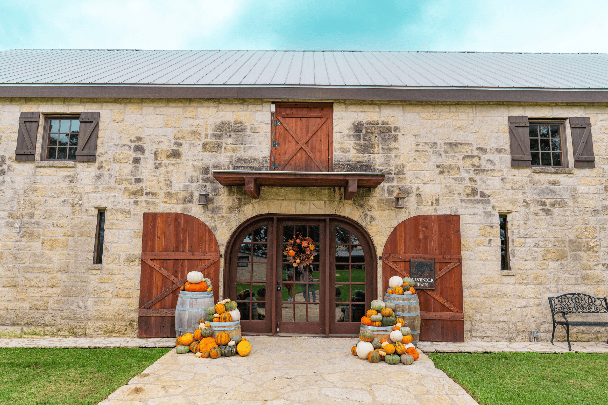 a stone building with pumpkins and barrels