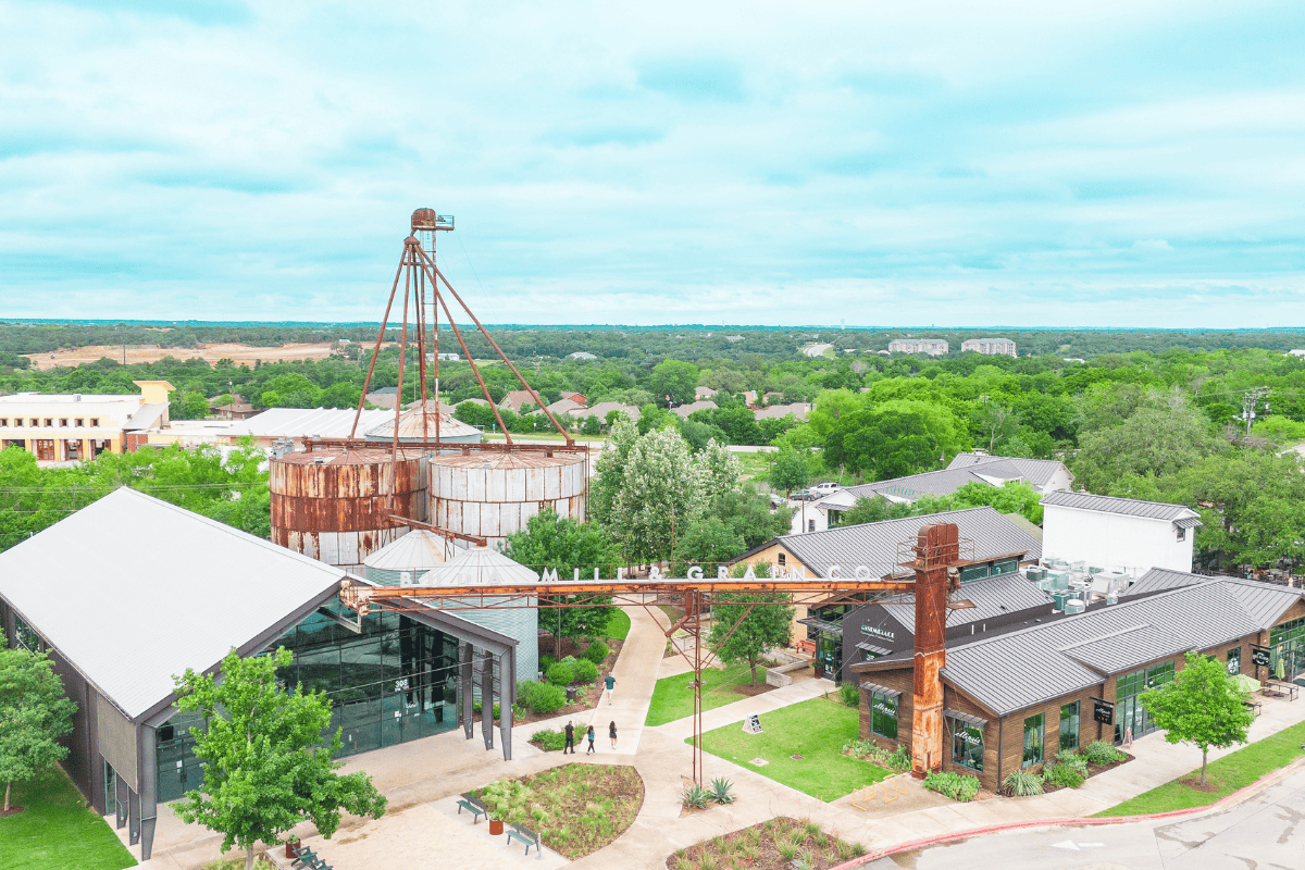 a large metal structure with trees in the background