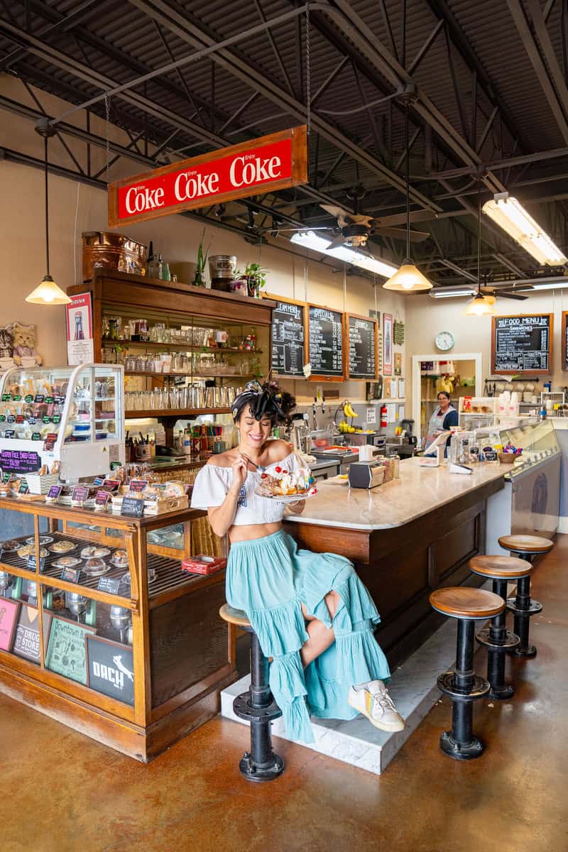 a woman sitting on a stool in a restaurant