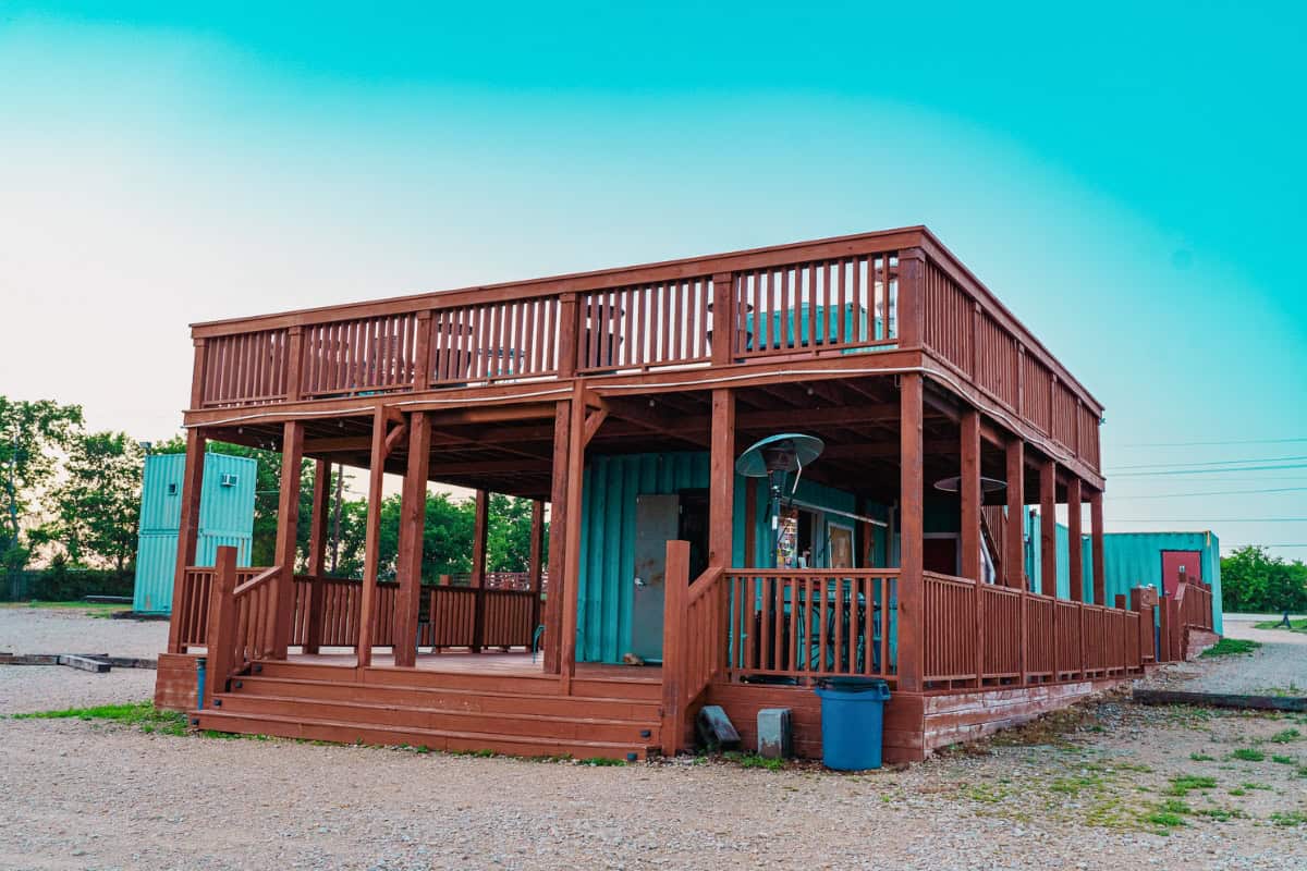 a wooden house with a blue container