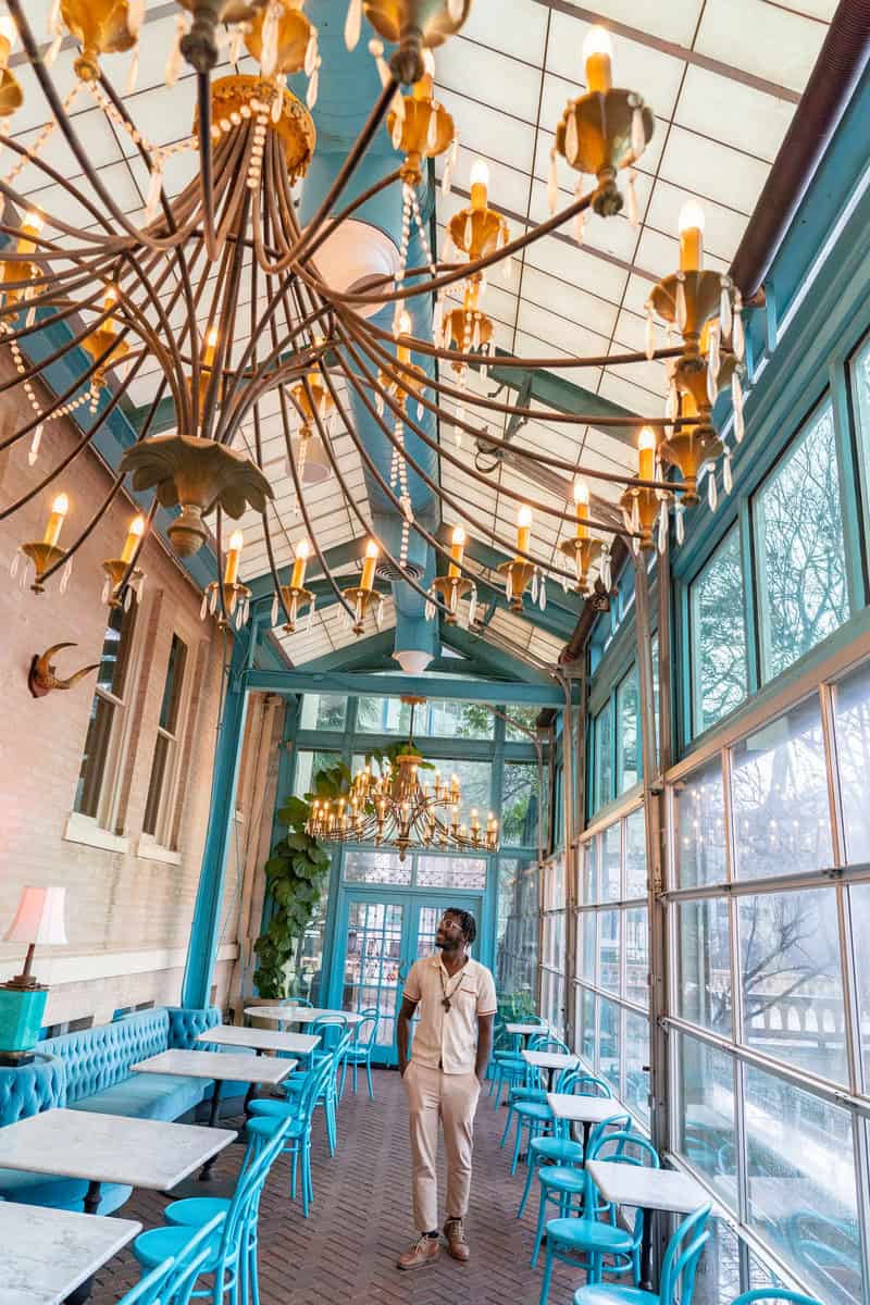 a man standing in a room with a chandelier