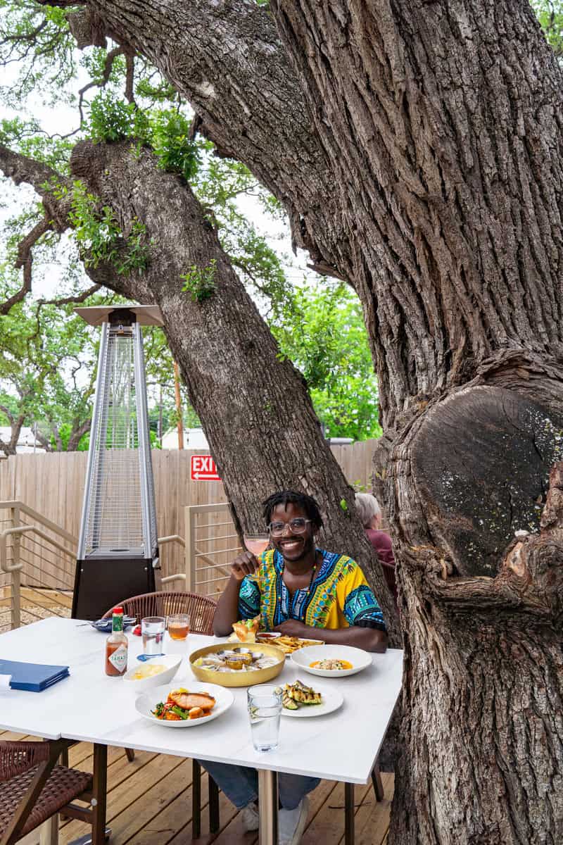 a man sitting at a table with food on it