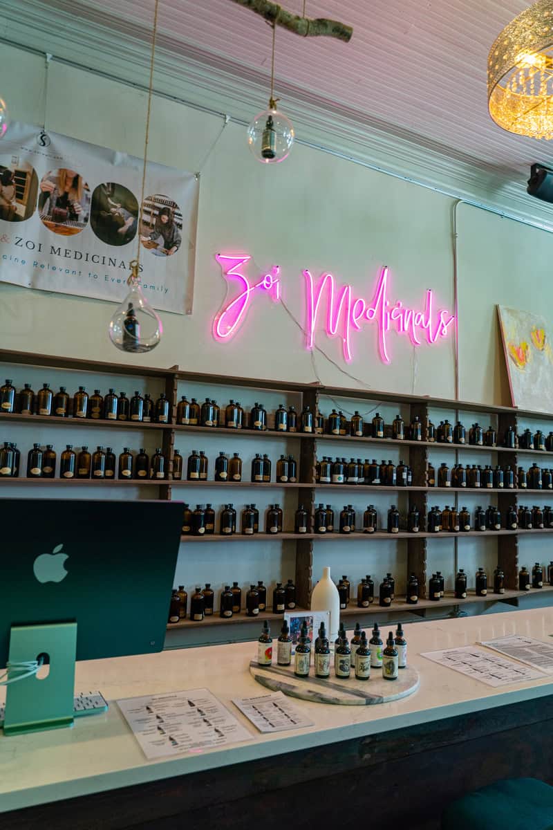 a shelf with bottles and a laptop on it