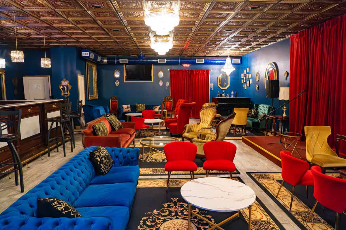 a room with a blue wall and red couches and tables