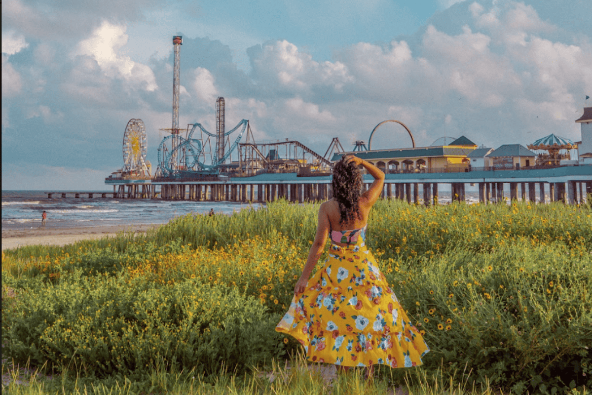 A woman in a floral dress enjoying the beach