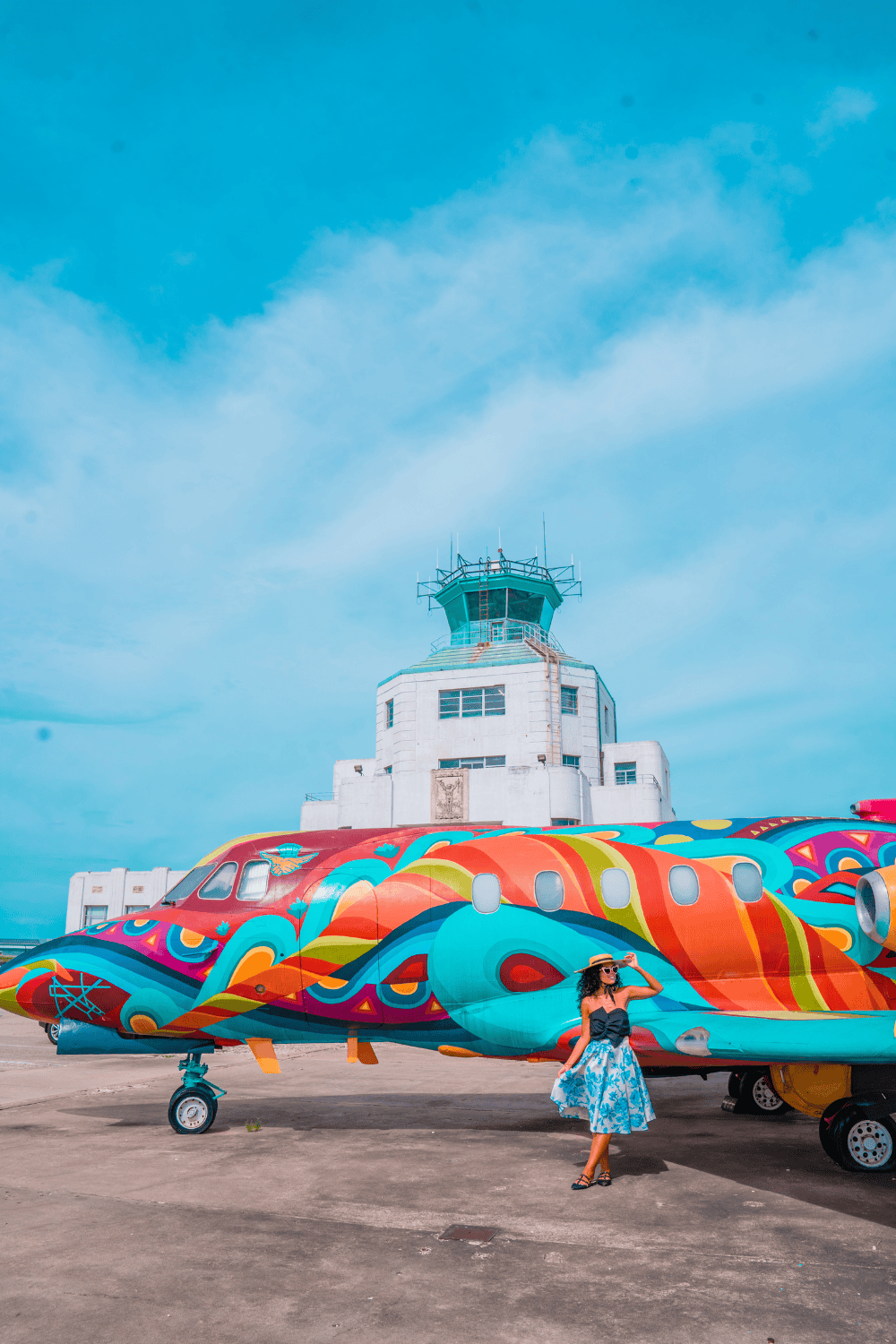 A woman with a colorful plane on the background on a flight museum.