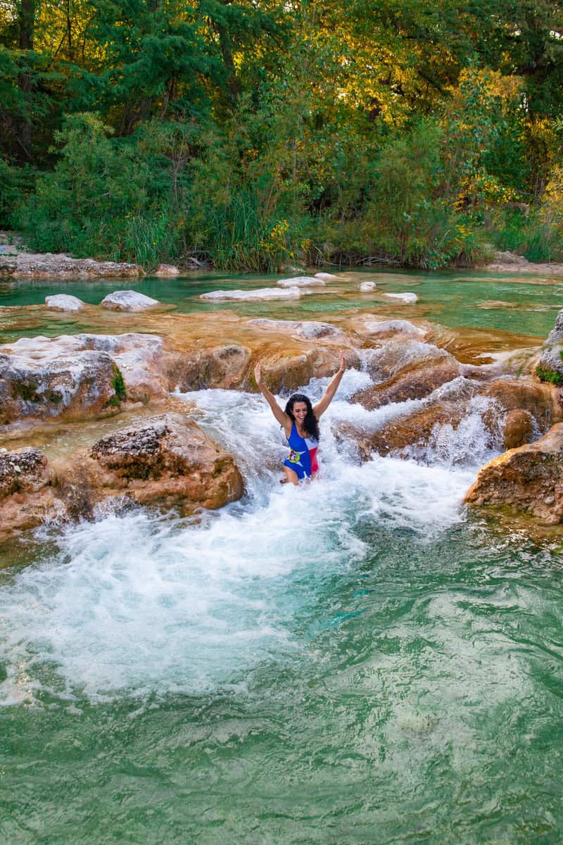 A woman enjoying in a serene river, enjoying the tranquility of the water.