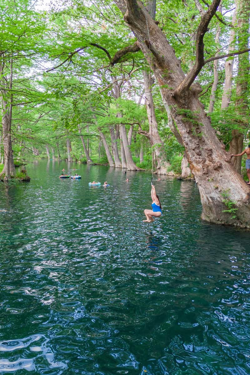 Woman energetically dives into lake, enjoying a refreshing swim.