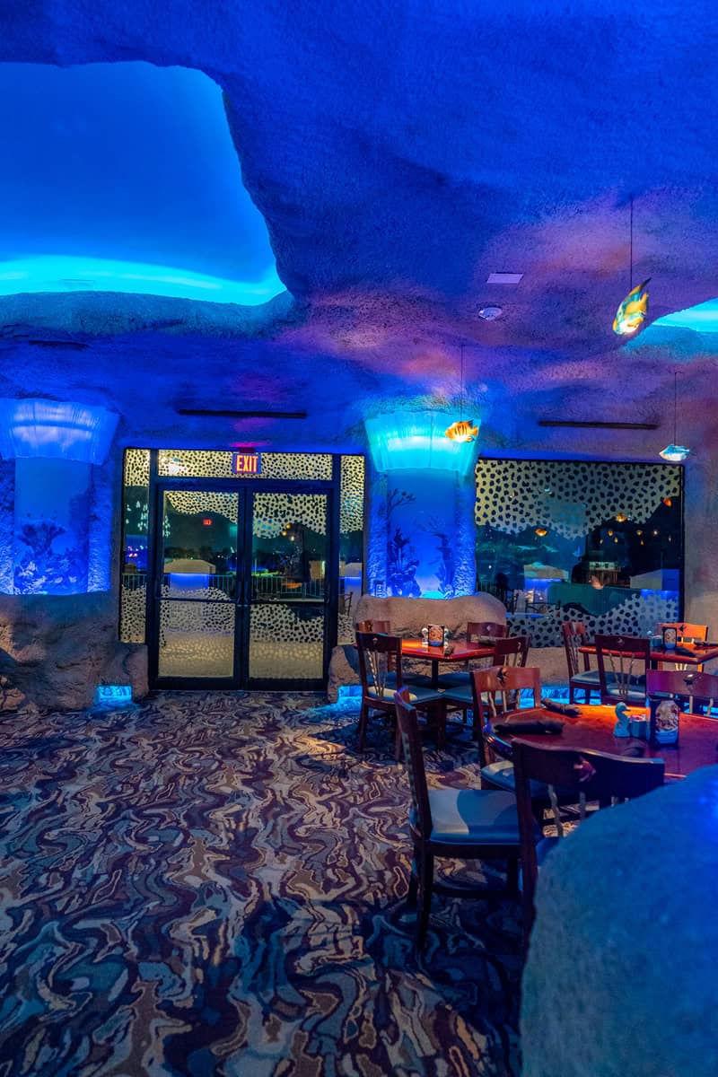 Modern restaurant with blue lighting and ceiling and aquariums