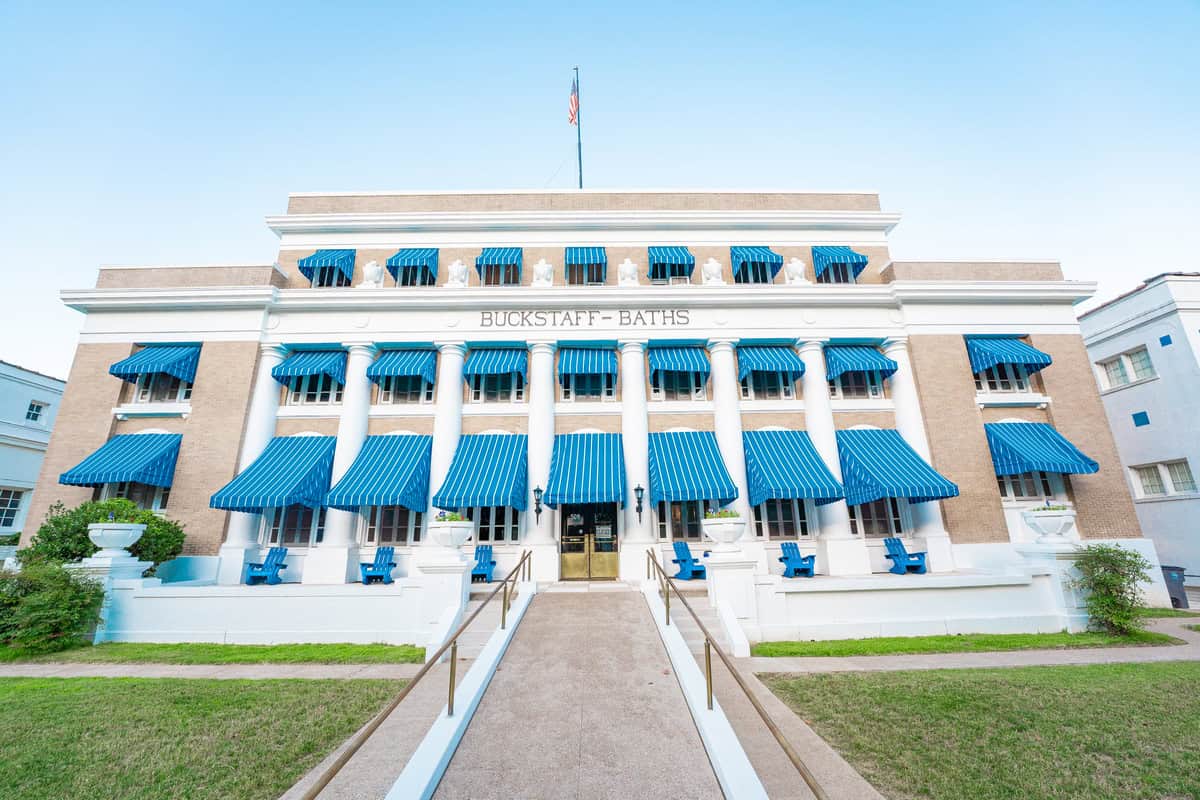 Blue awnings adorn a big building under clear skies.