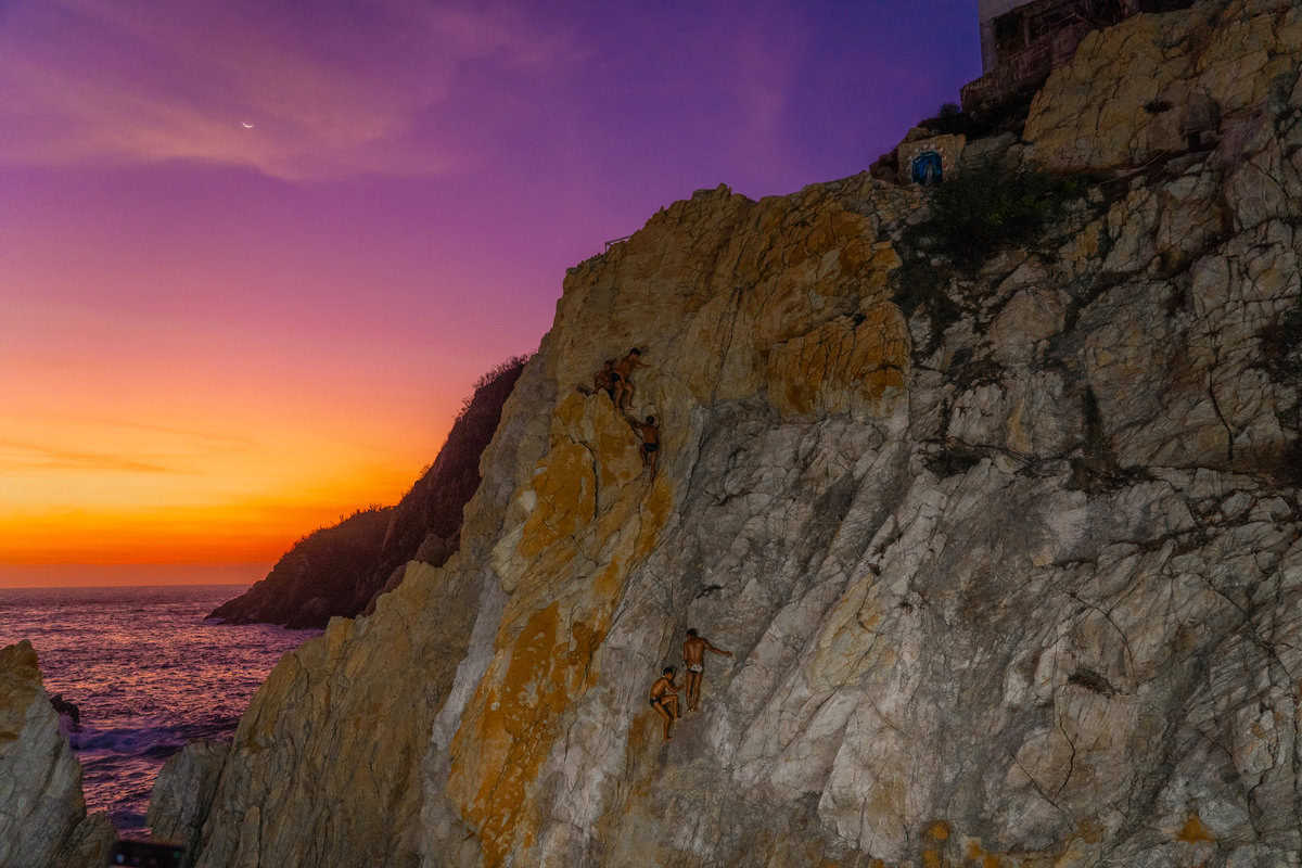 a group of people climbing a cliff