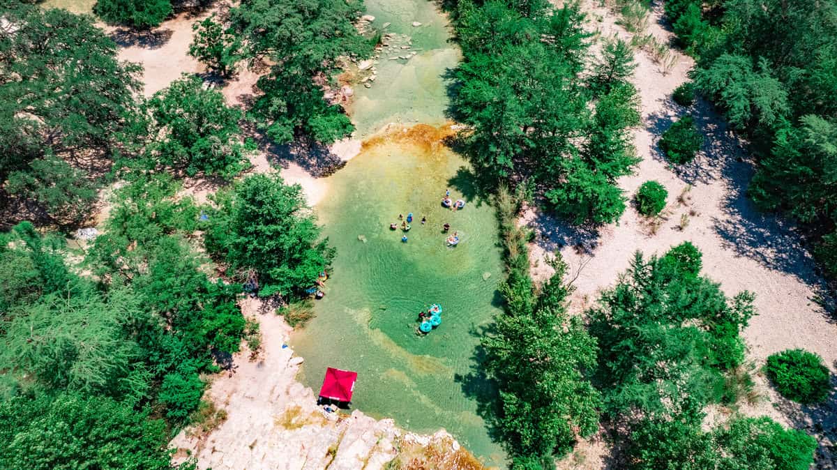 a group of people in a river surrounded by trees