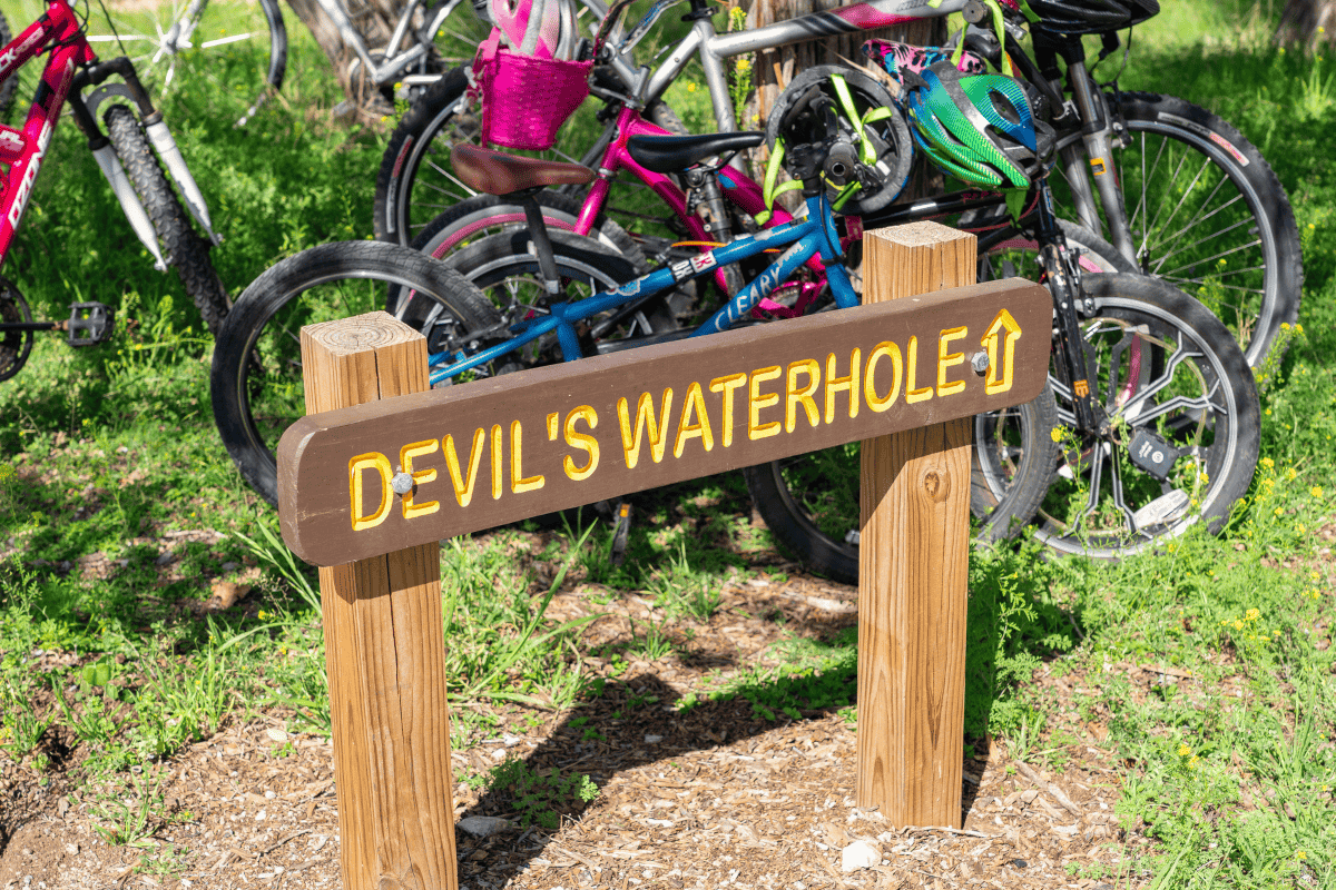 Sign for Devil's Waterhole, a popular swimming spot in Inks Lake State Park, Texas.