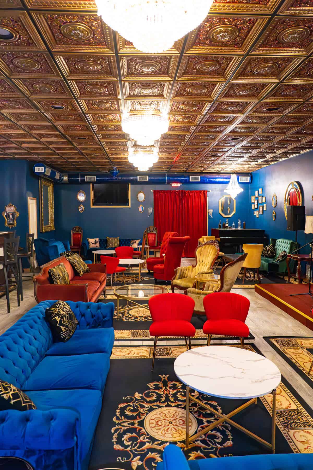 a room with a blue wall and red couches and a piano