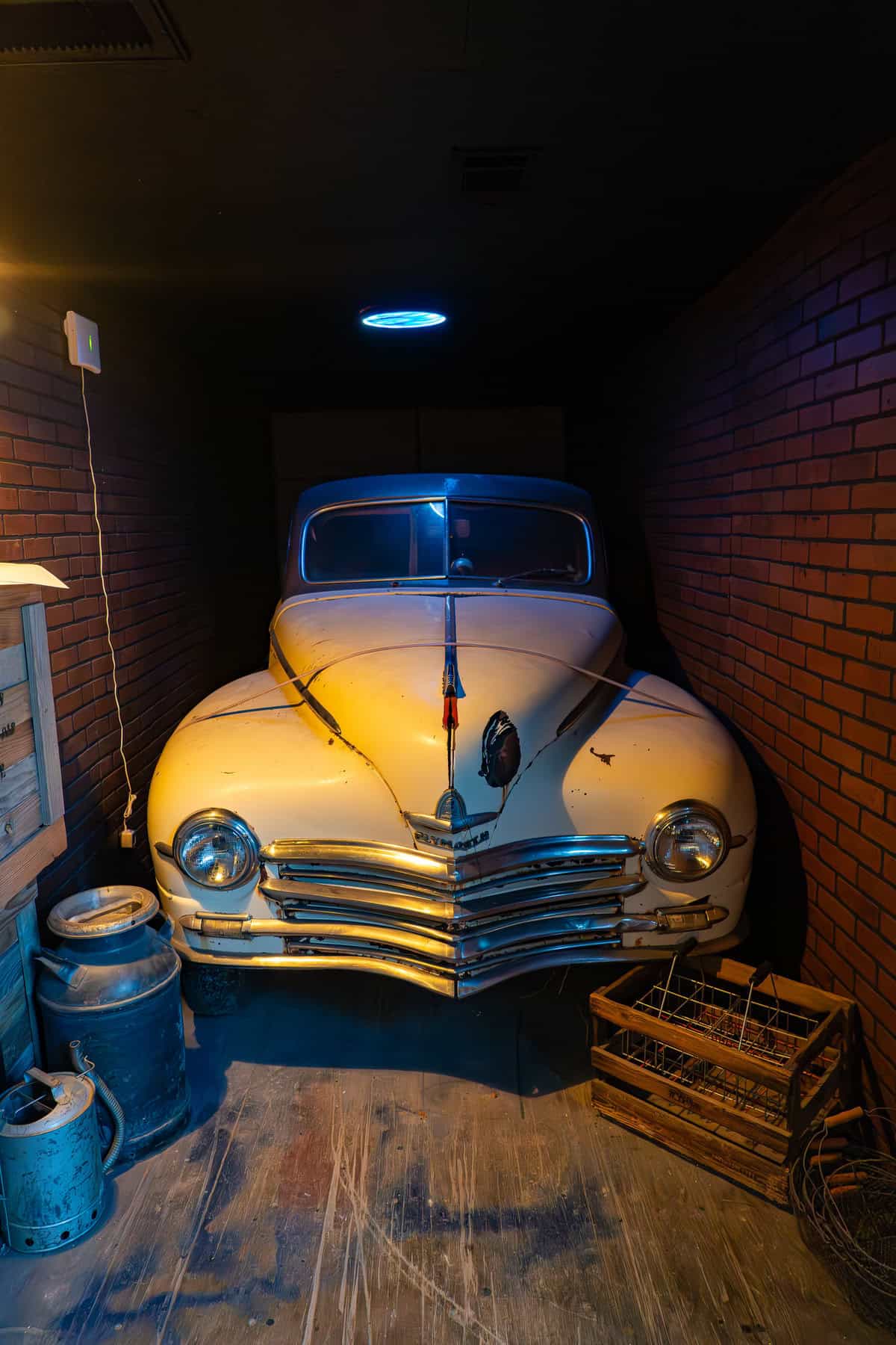 a old white car in a dark room