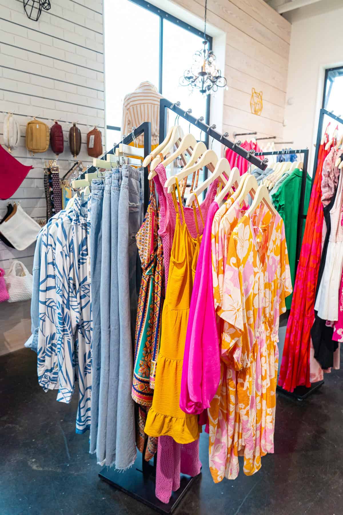 a group of clothes on swingers in a clothing store