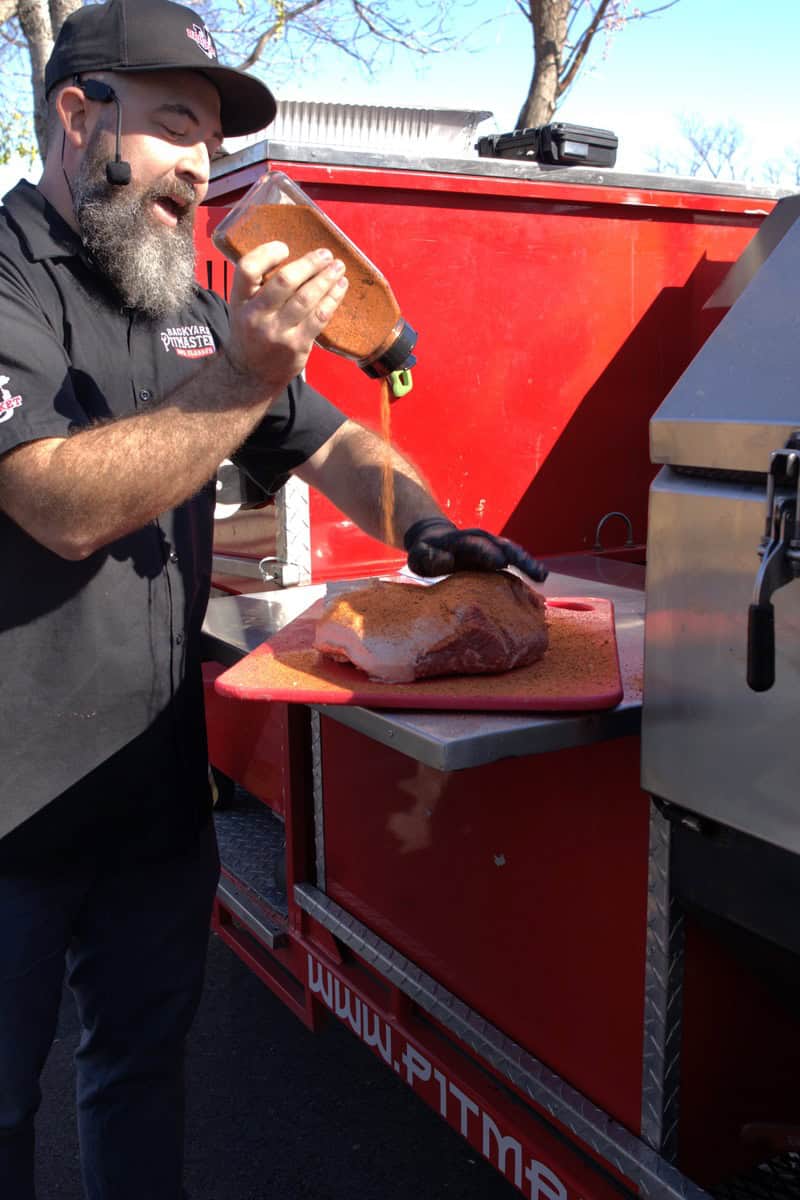 A man demonstrating on marinating a meat for a BBQ.