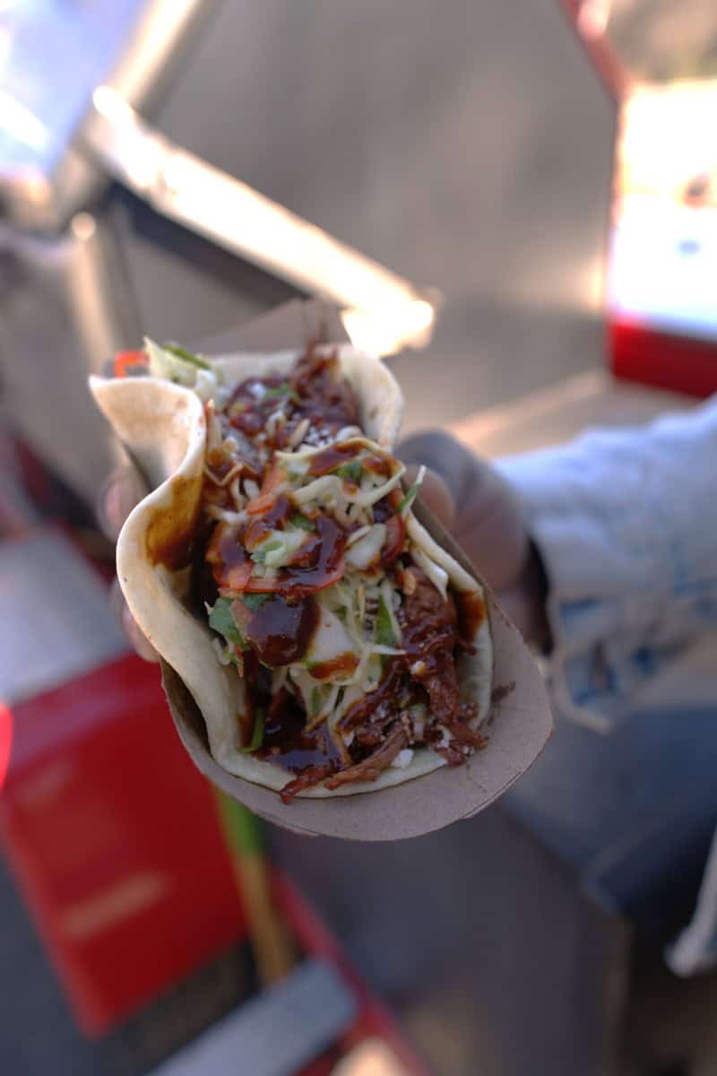 A hand holding a mouth-watering taco.