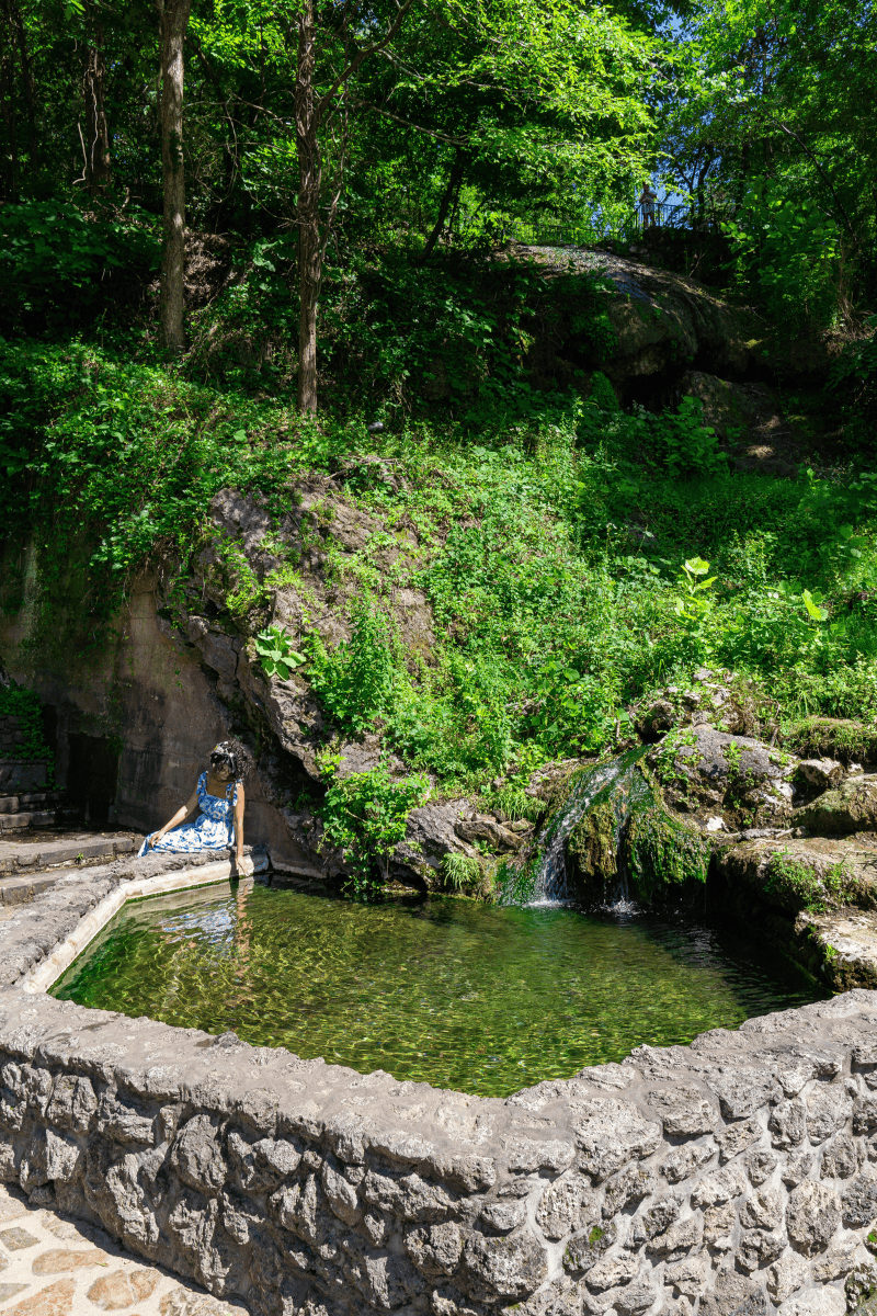 Serene scene of a woman relaxing in a forest pool