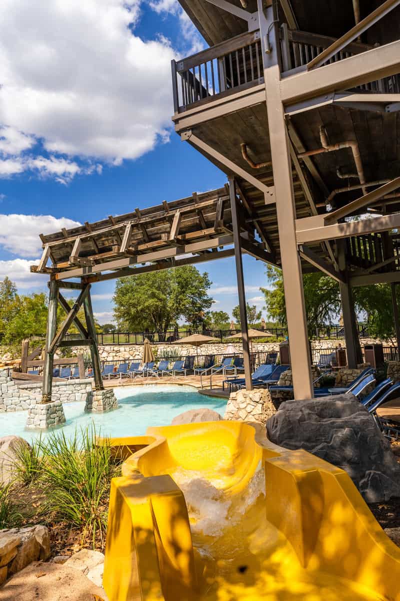 a pool with a slide and a bridge