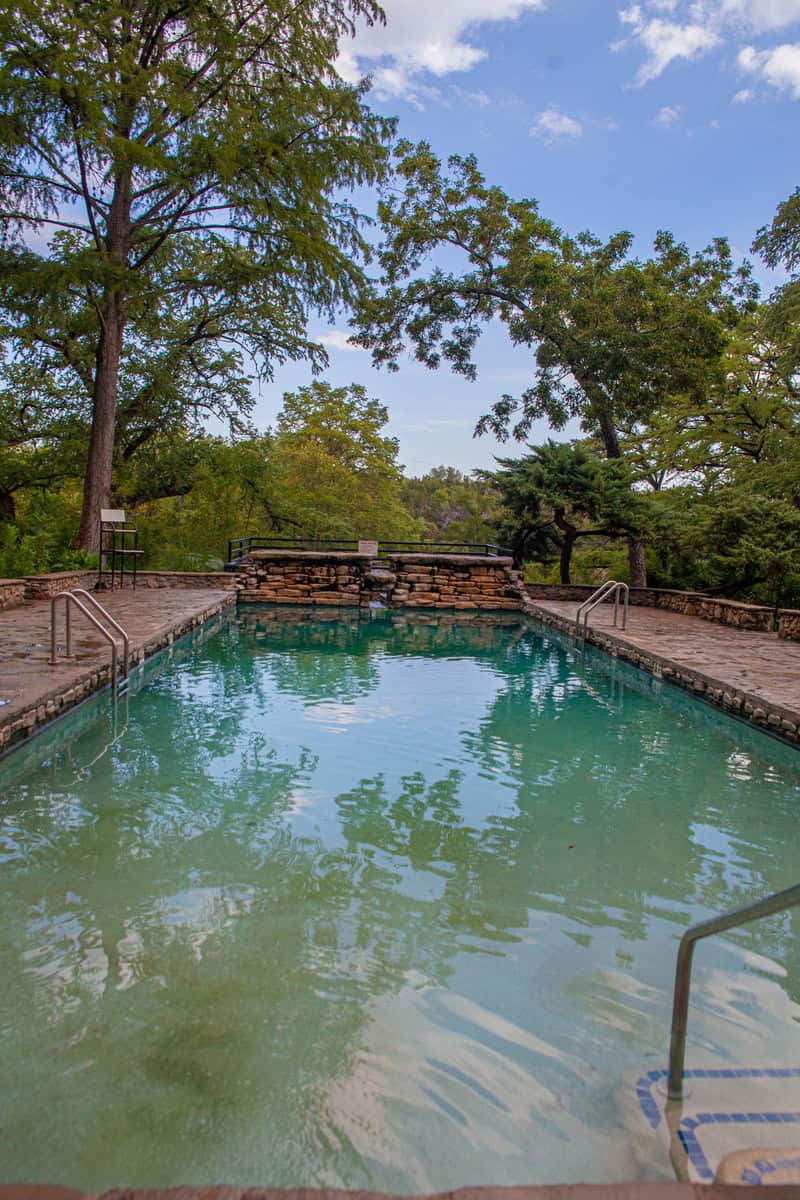 A serene pool surrounded by a protective fence.