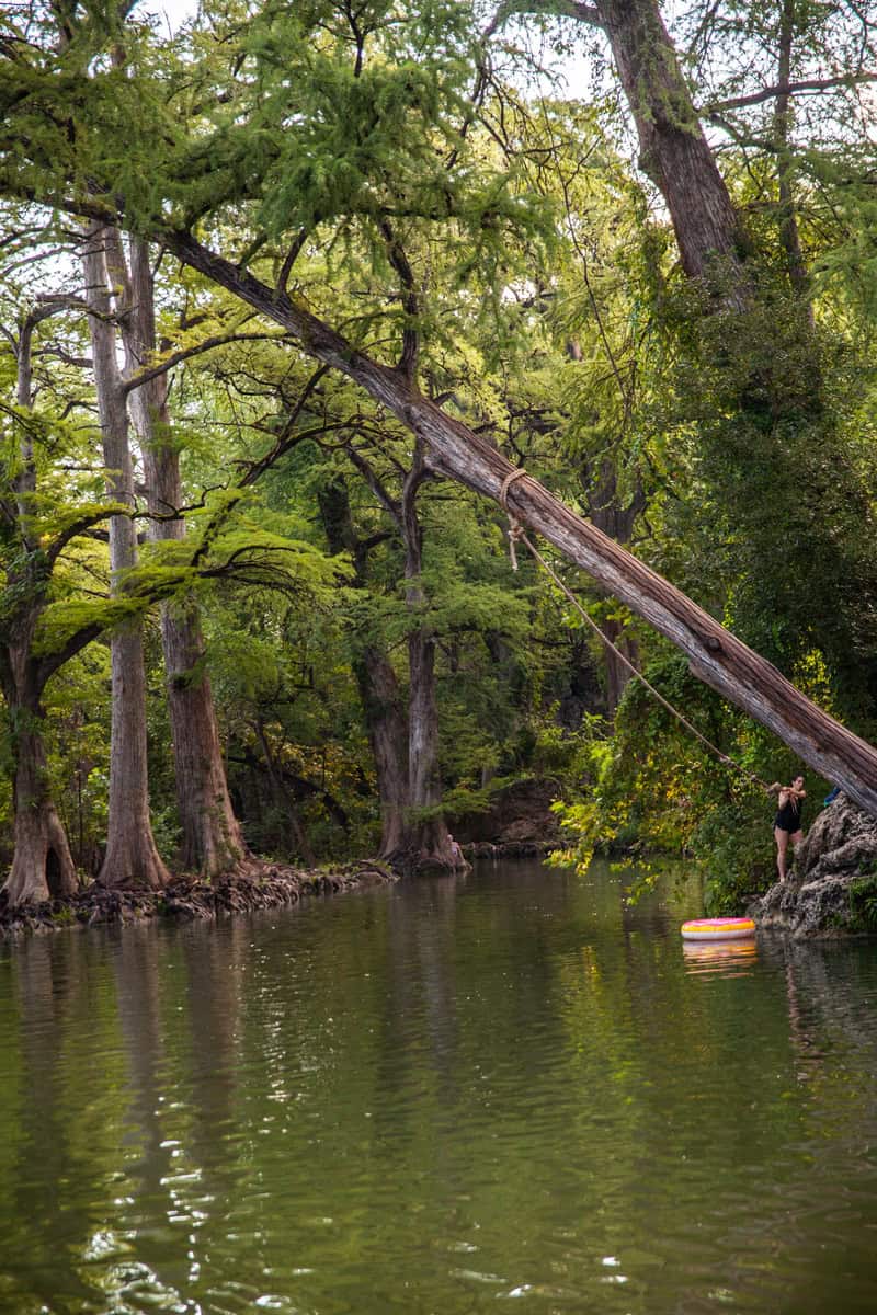 A serene scene of a woman standing on a raft in a river.