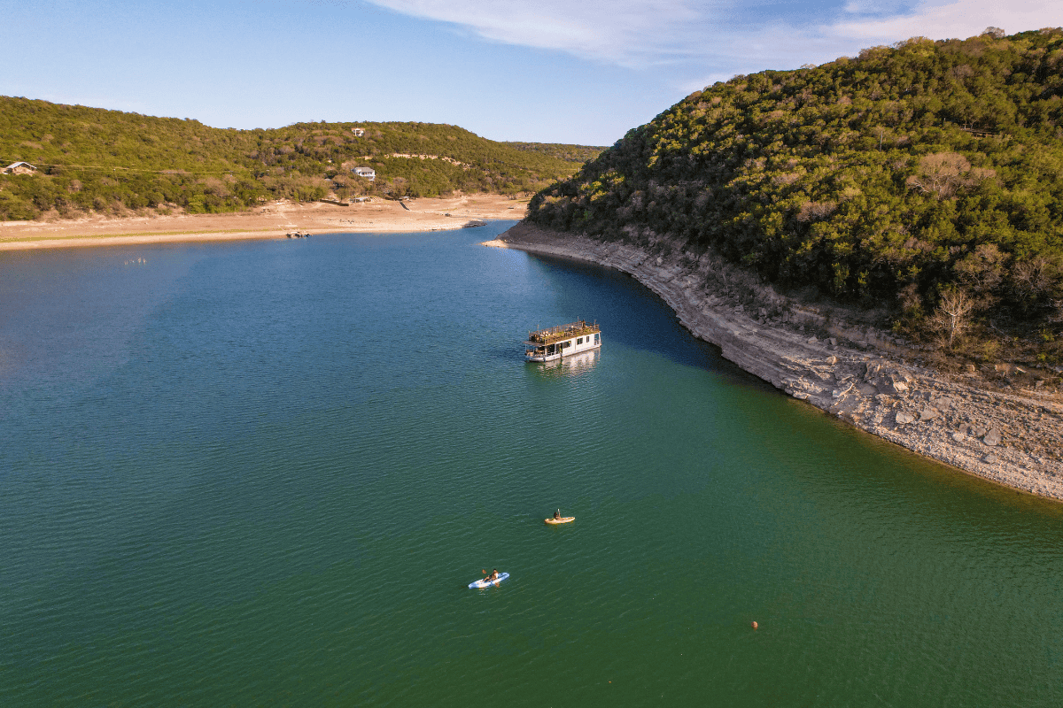 Serene image of a boat gently floating in the center of a peaceful lake.