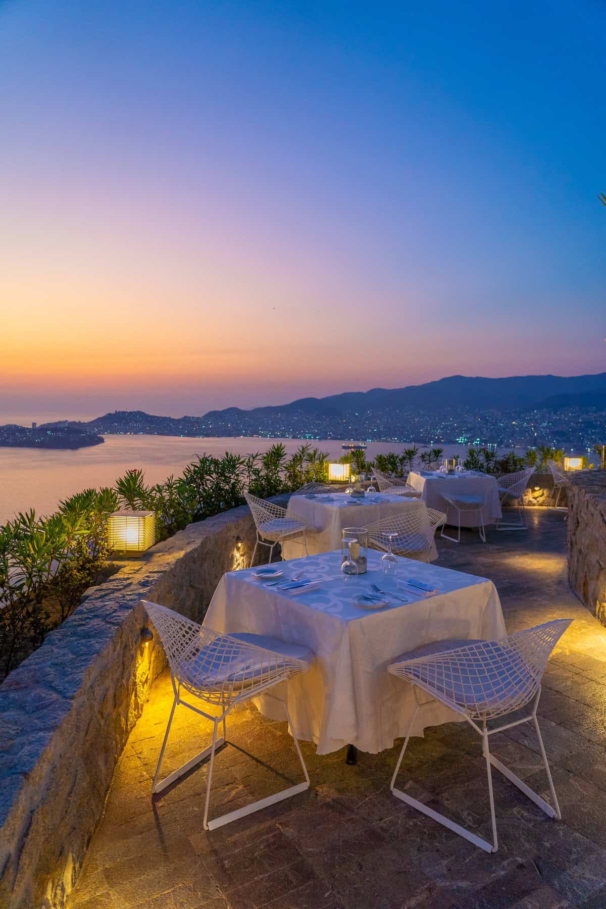 a restaurant with tables and chairs overlooking a body of water