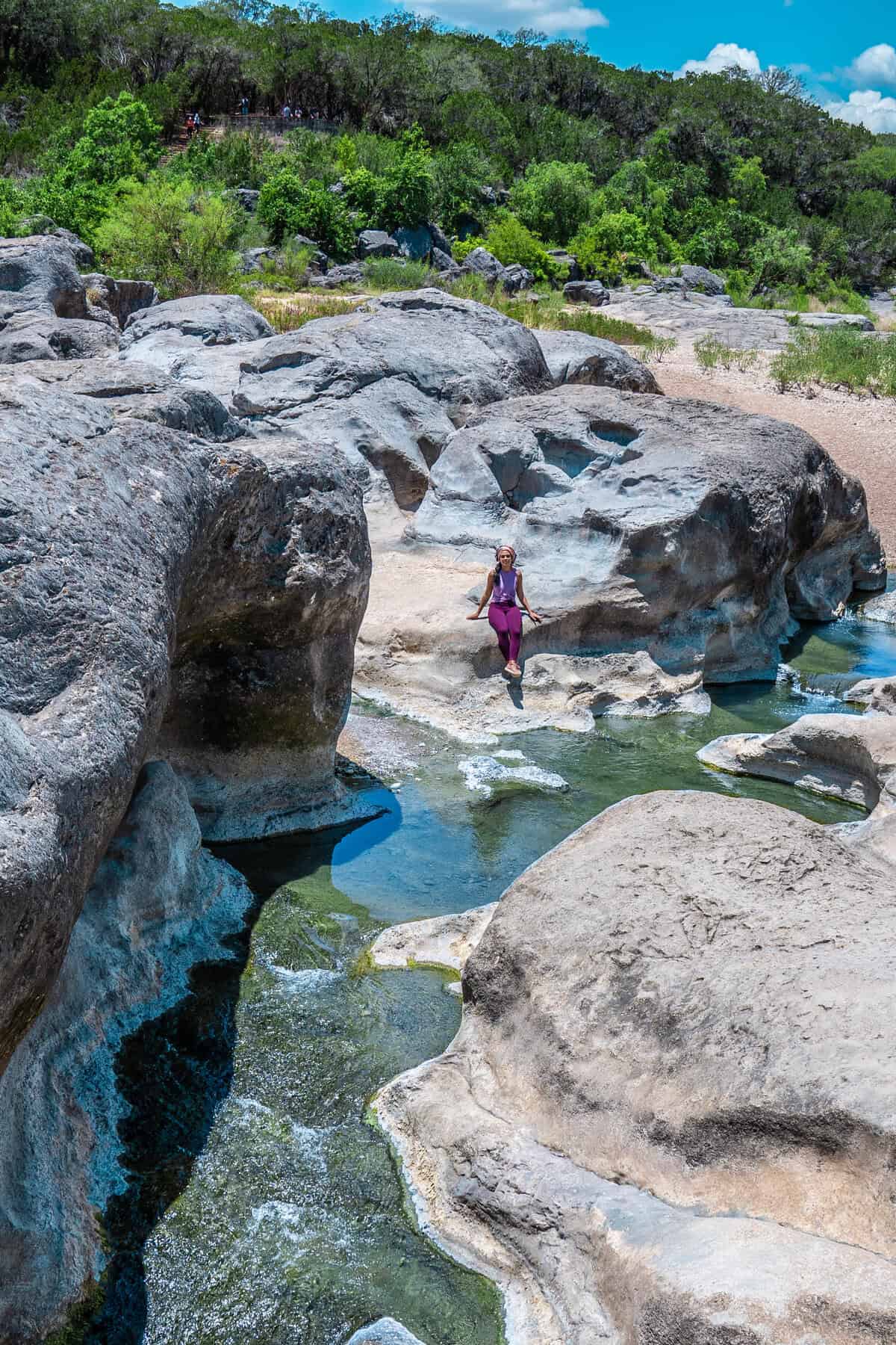 a woman standing on rocks in a river