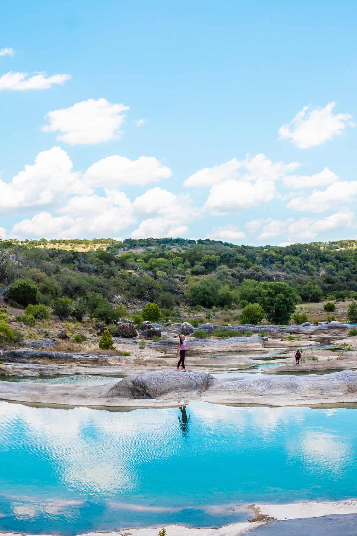 Scenic view of a person walking by a tranquil blue water body