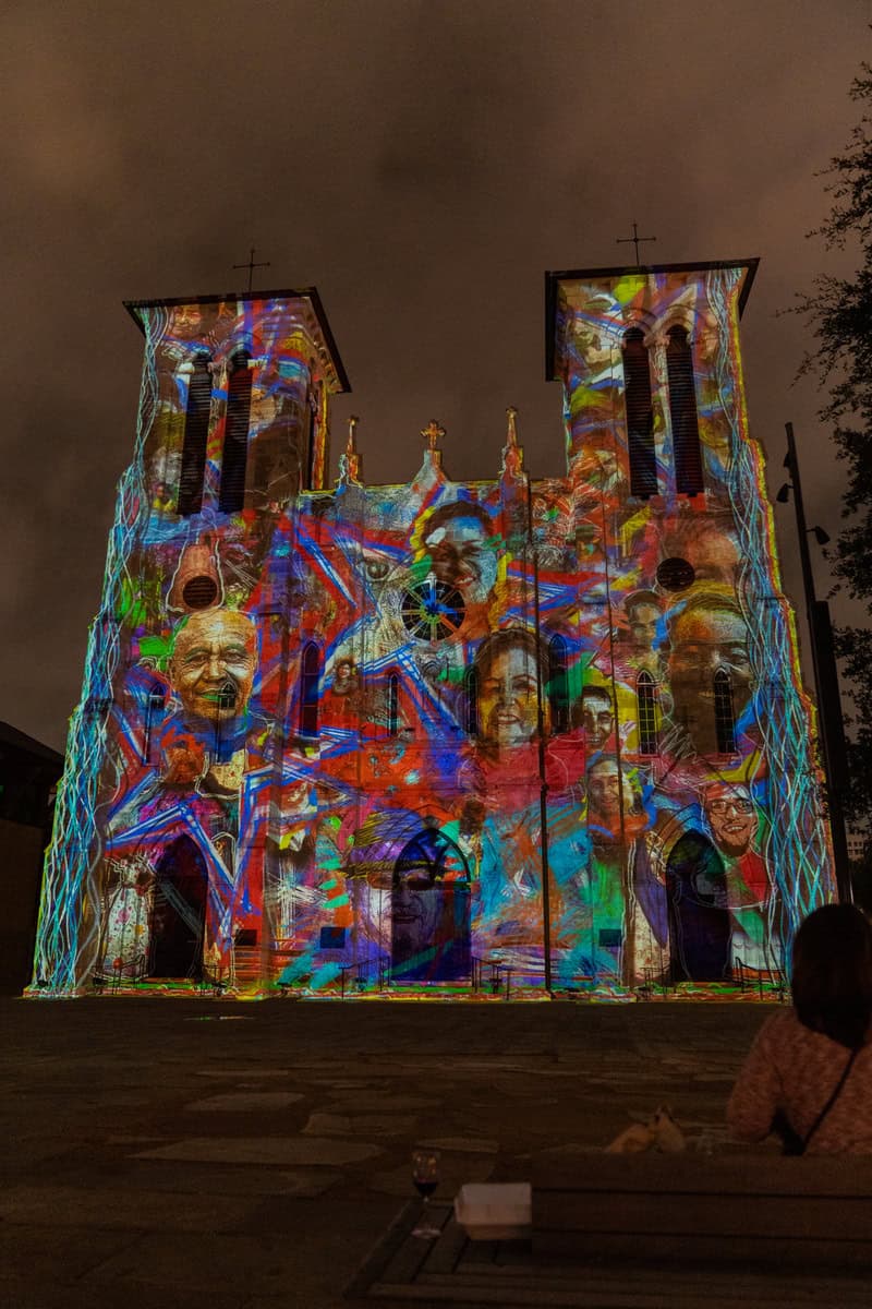 A historic church illuminated with colorful lights at night.