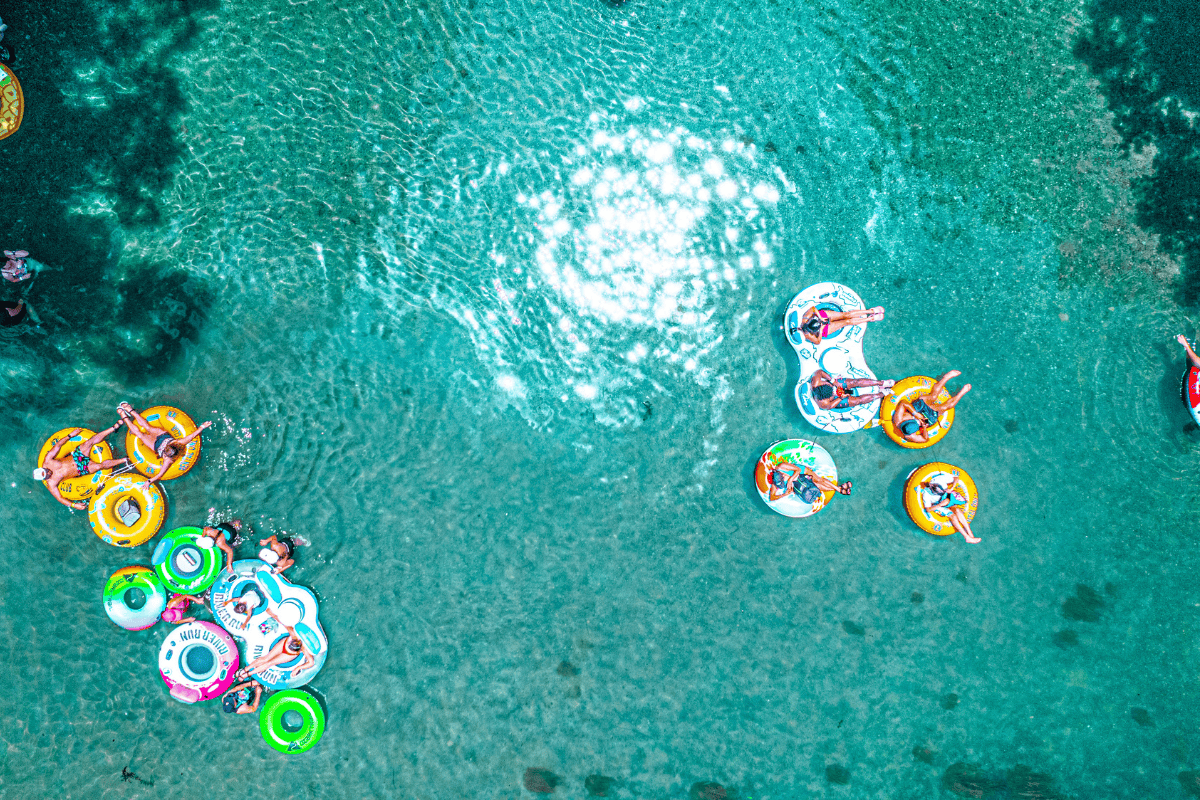 A group of people floating on inflatable tubes in the water.